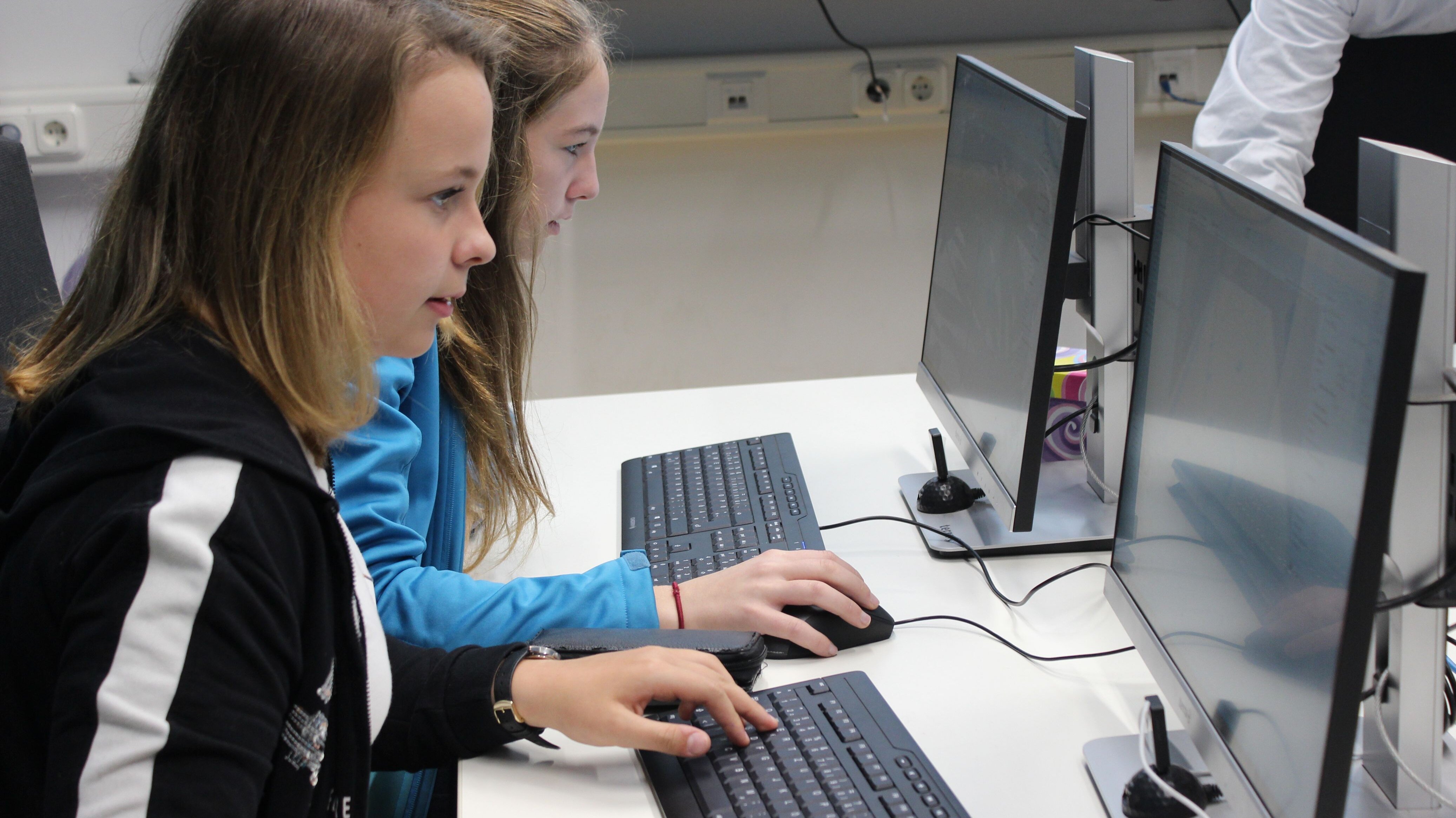 Zwei Mädchen arbeiten an Computer Monitoren