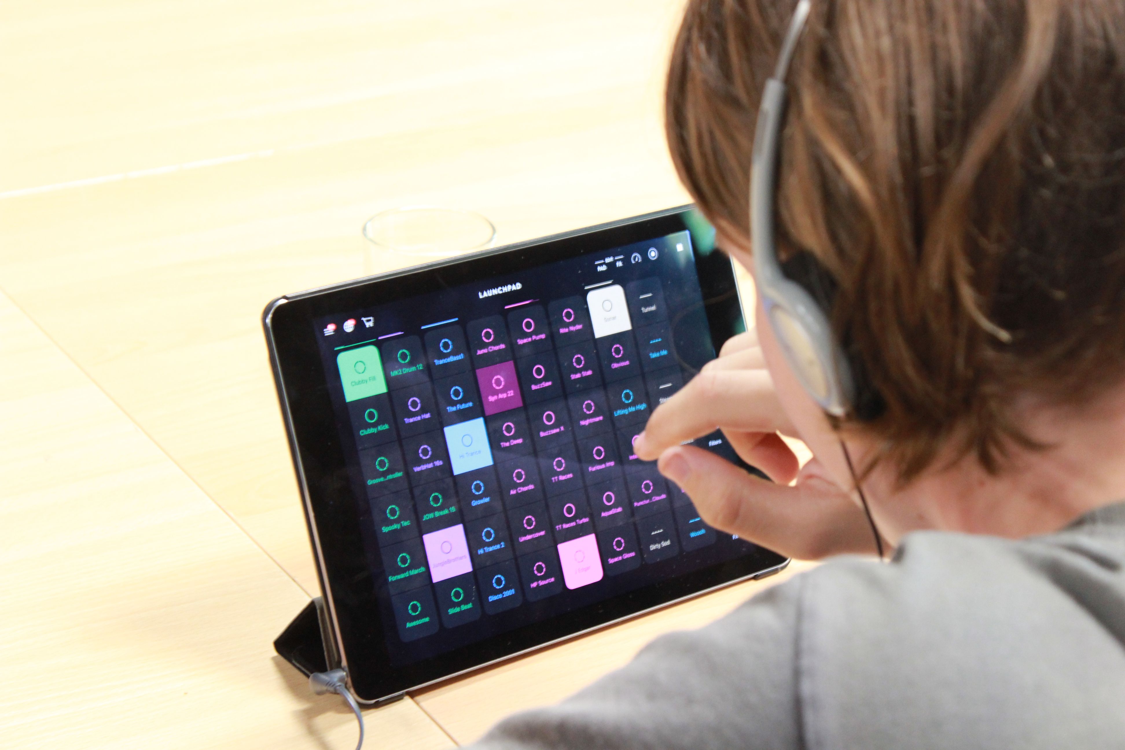 Kind mit Kopfhörern verwendet eine Musik-App am Tablet