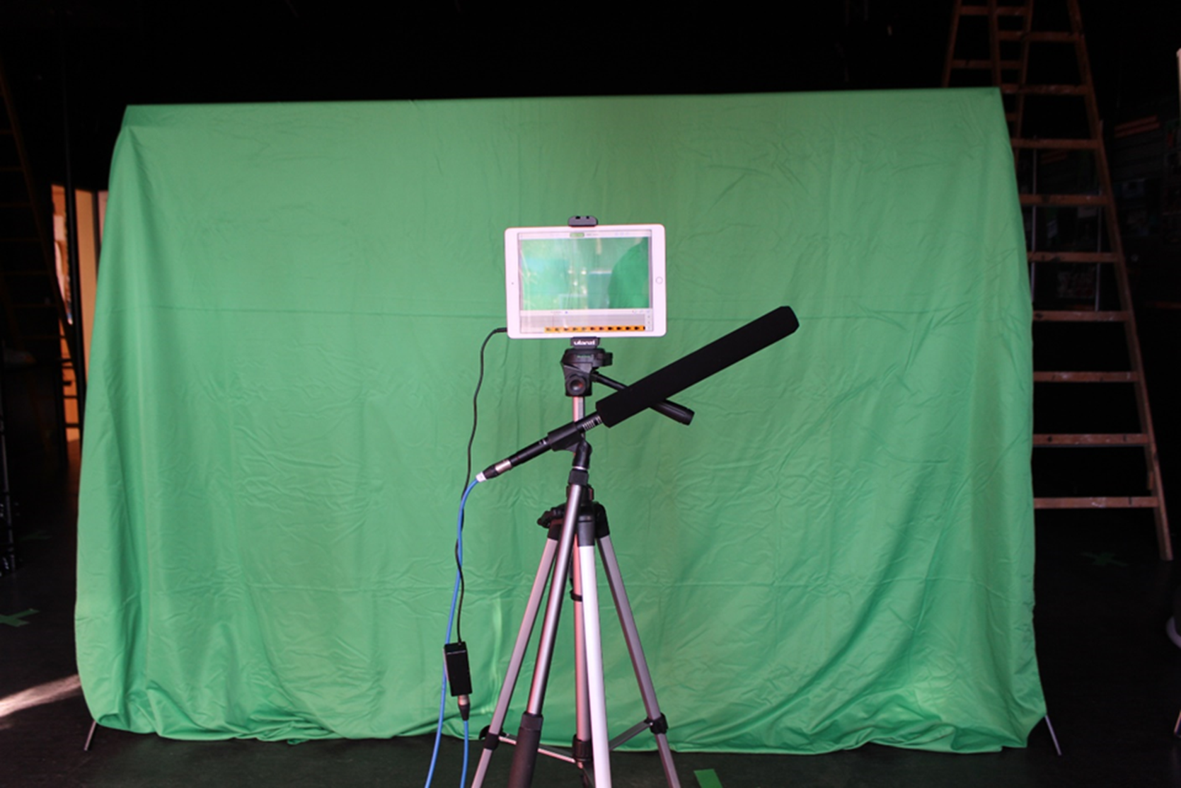 Green Screen Stoff mit einem Stativ, einem iPad und einem Mikrofon