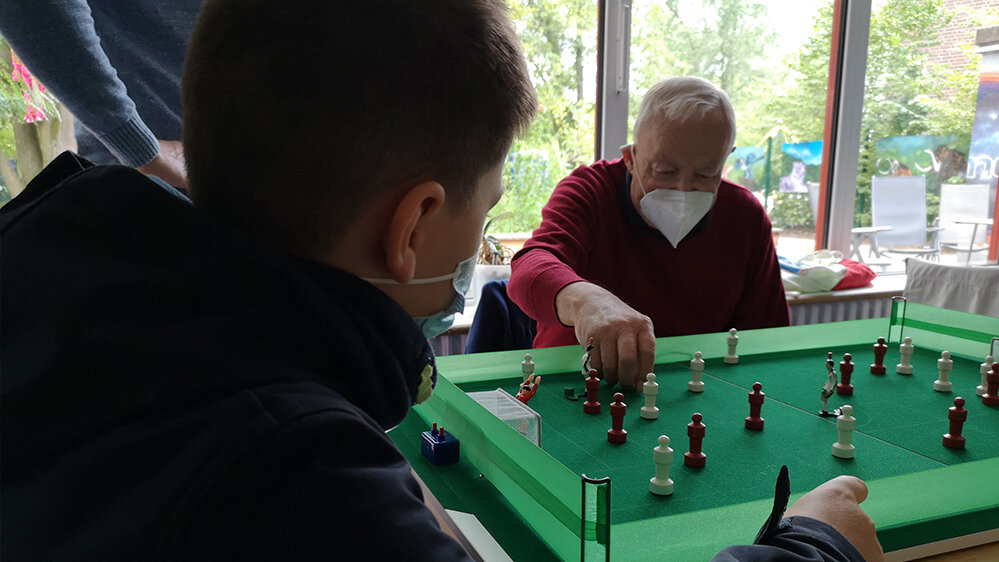Junge und Mann spielen Mini-Fußballspiel