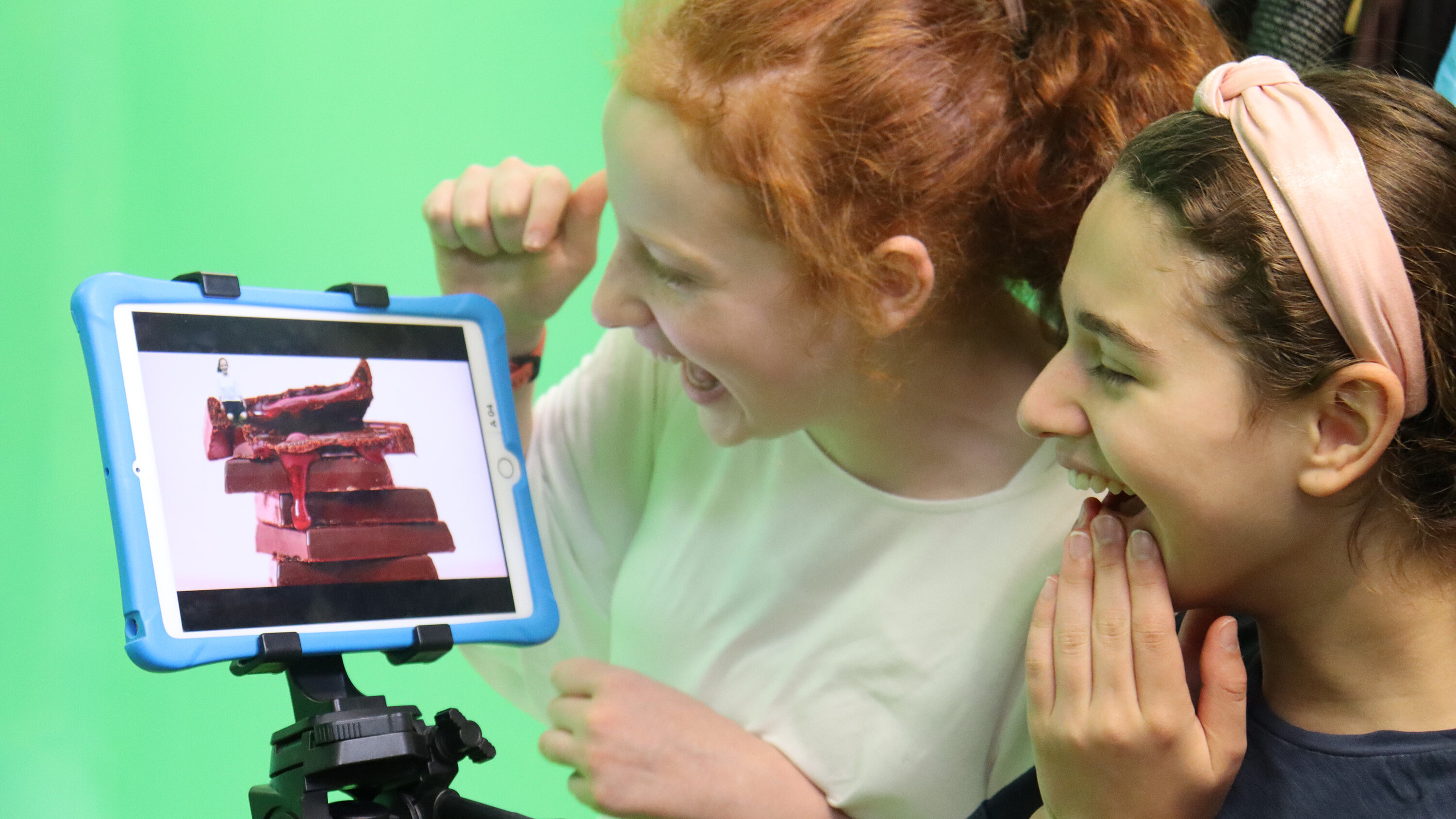 zwei Mädchen schauen ein Foto auf dem iPad an und lachen