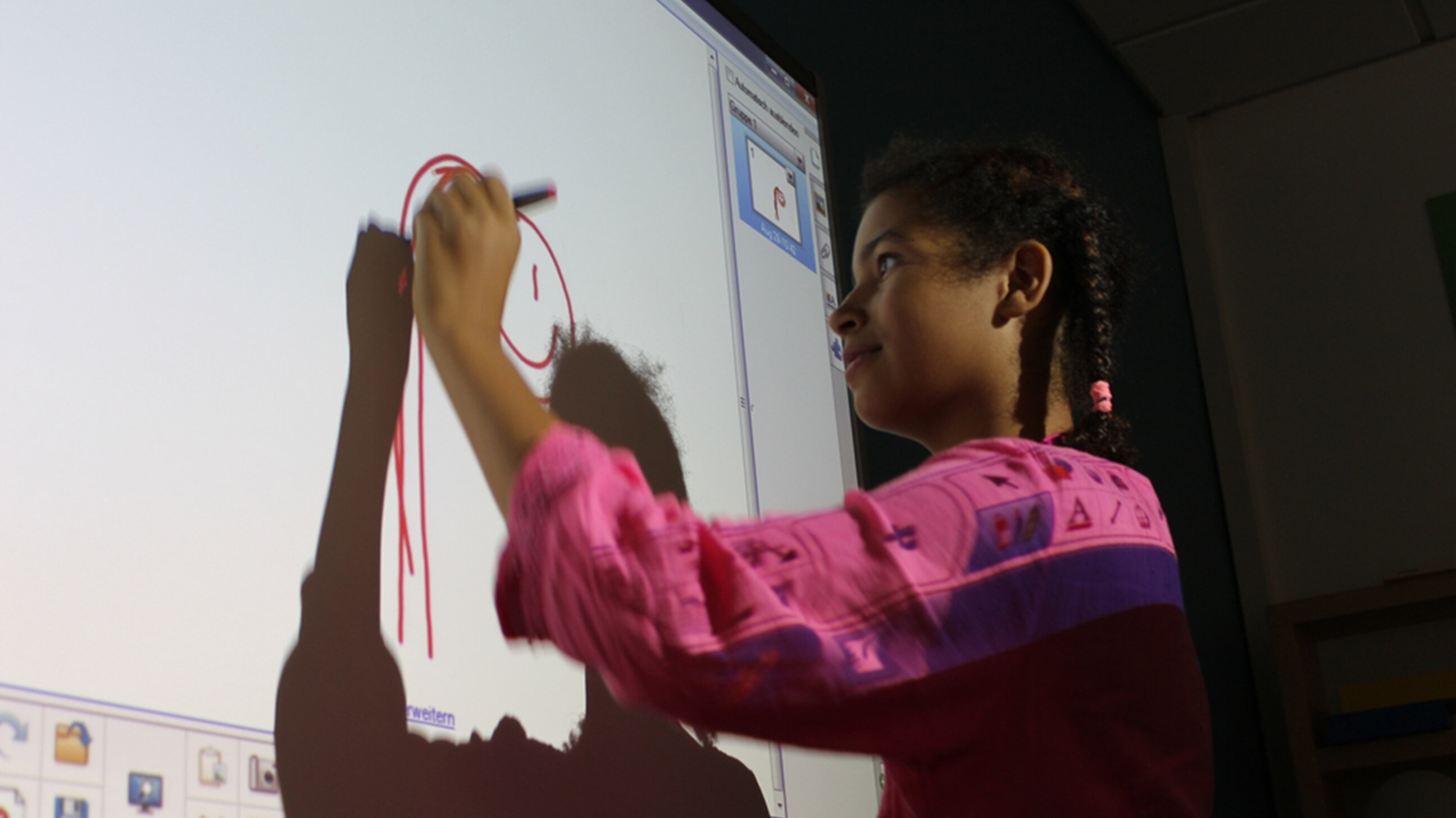 Mädchen malt ein Bild am Smartboard