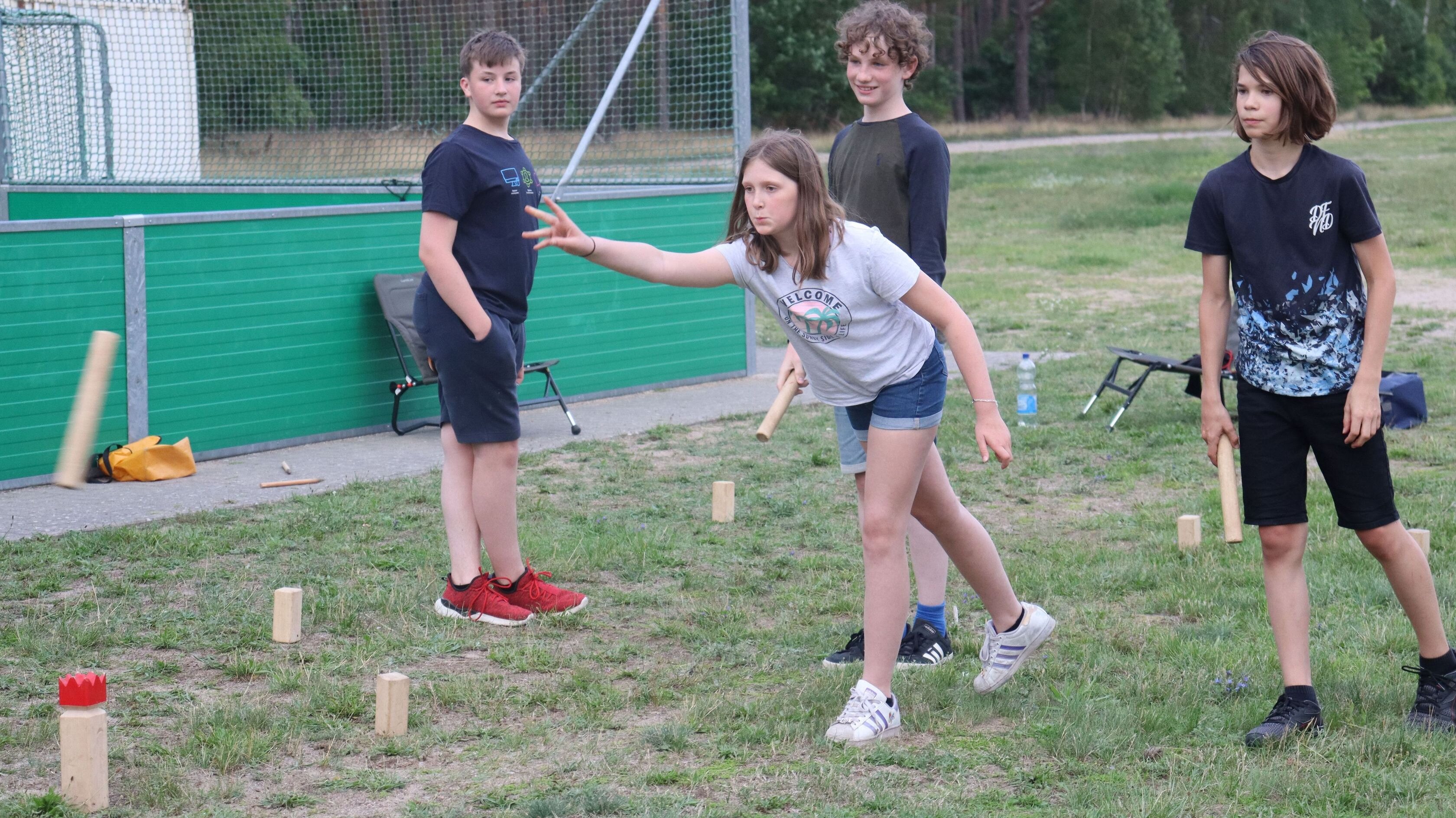 Jugendliche spielen Vikingerschach auf dem Rasen