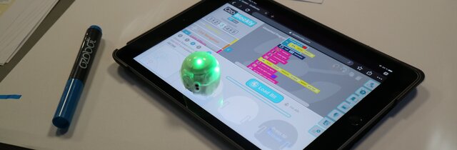 kleiner Roboter steht auf Tablet zum Programmieren