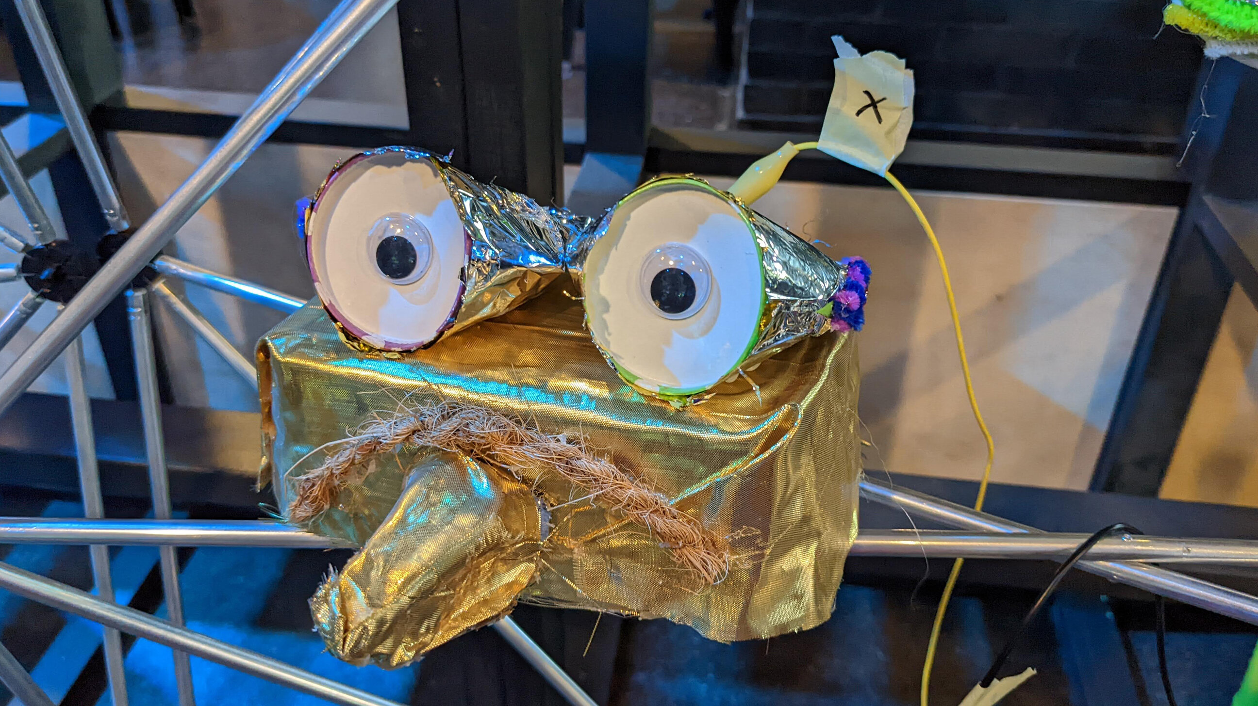 gebasteltes Klangmonster in Gold mit großen Augen und einer Krokodilklemme