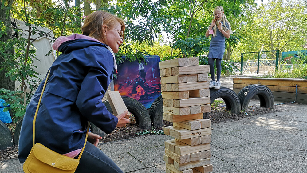 Frau und Kind spielen Riesenstapelspiel