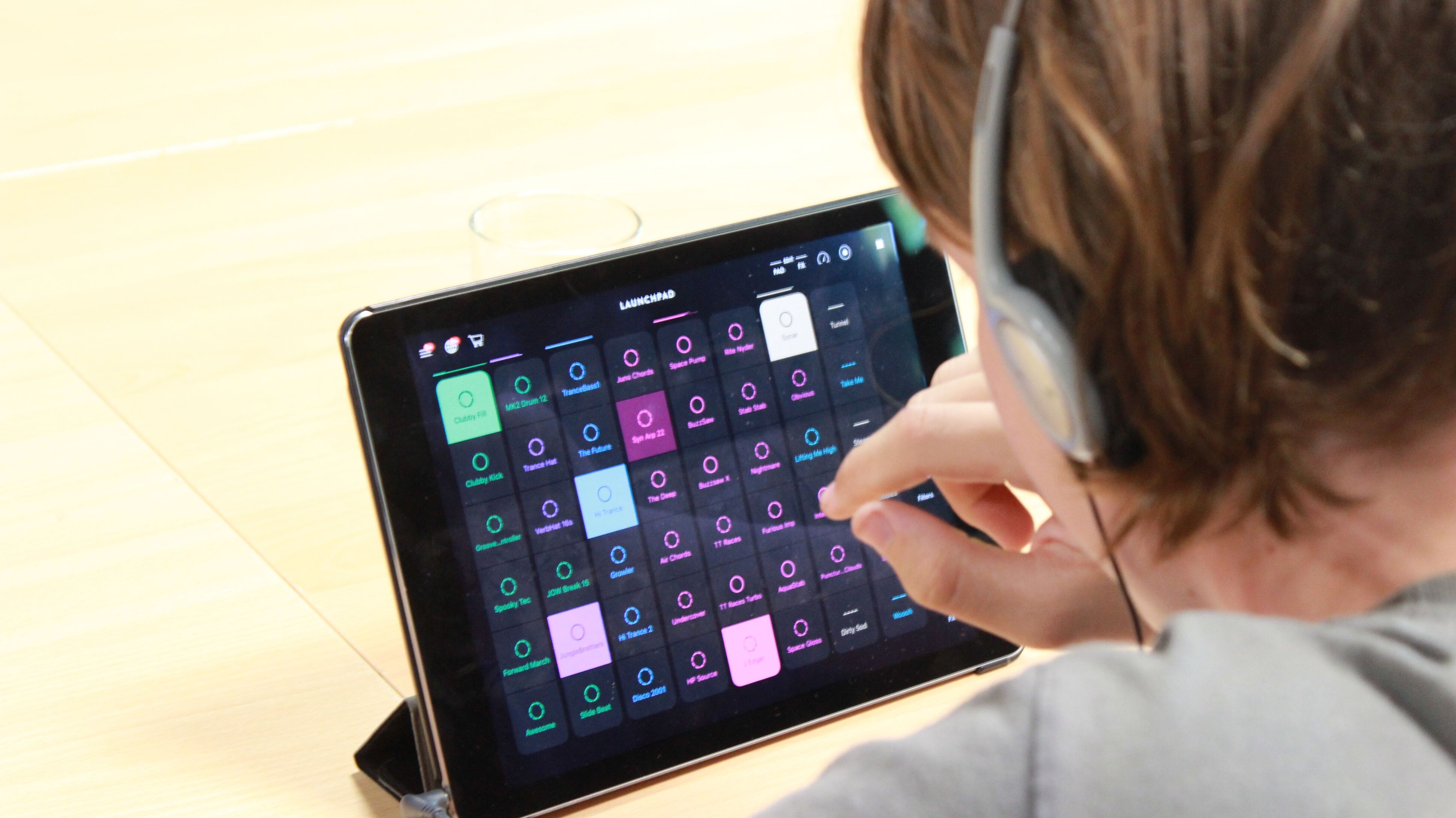Kind mit Kopfhörern verwendet eine Musik-App am Tablet