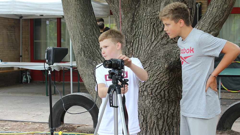 Zwei Jungen bereiten eine Kamera vor