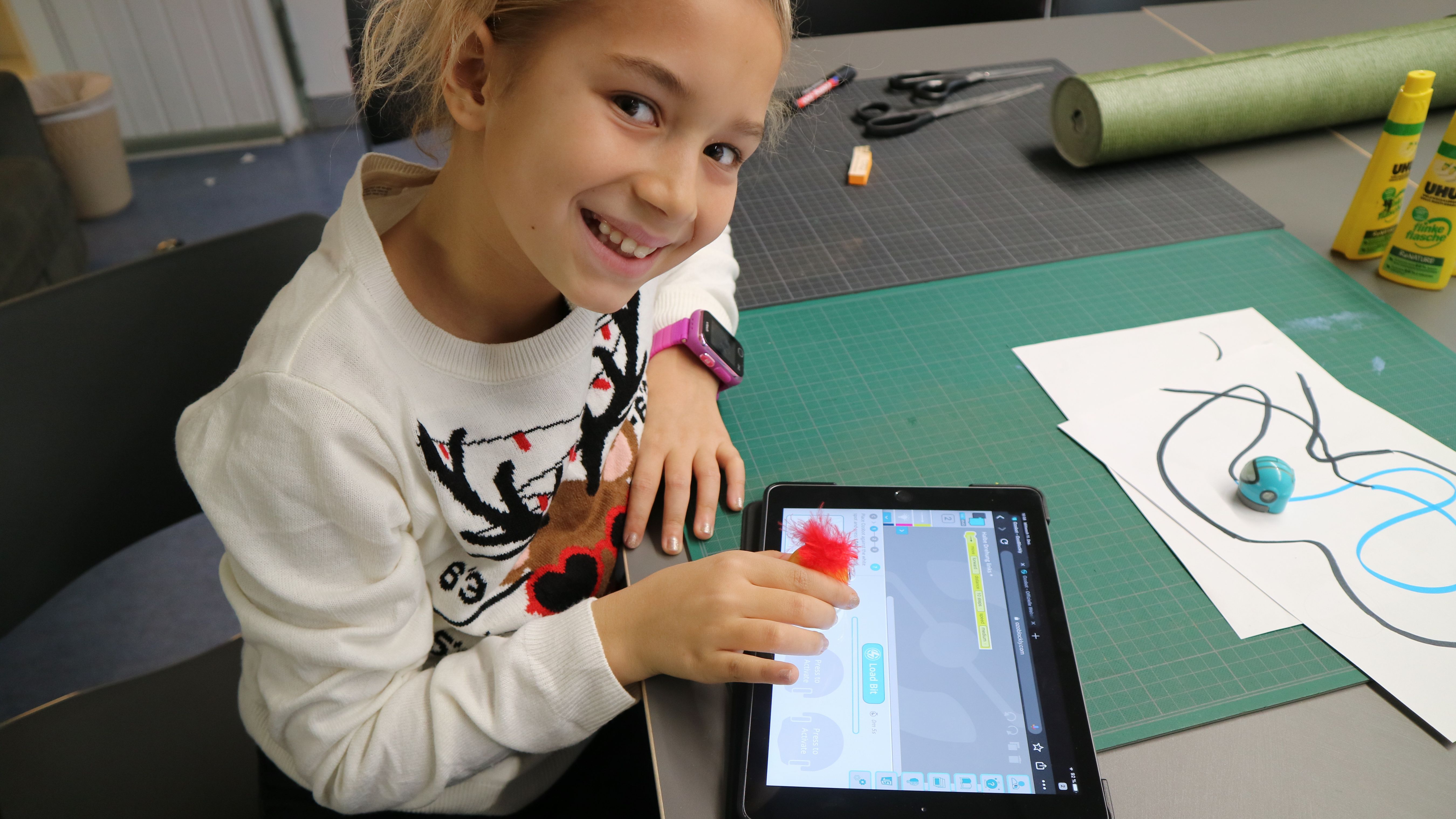 Mädchen programmiert einen Roboter mit dem Tablet