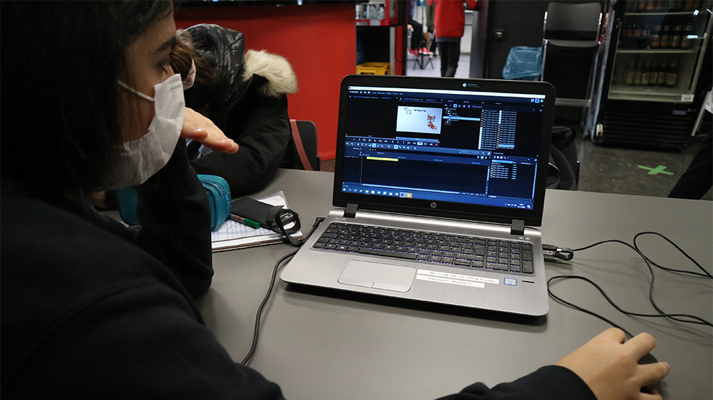 Mädchen schneidet am Laptop einen Film