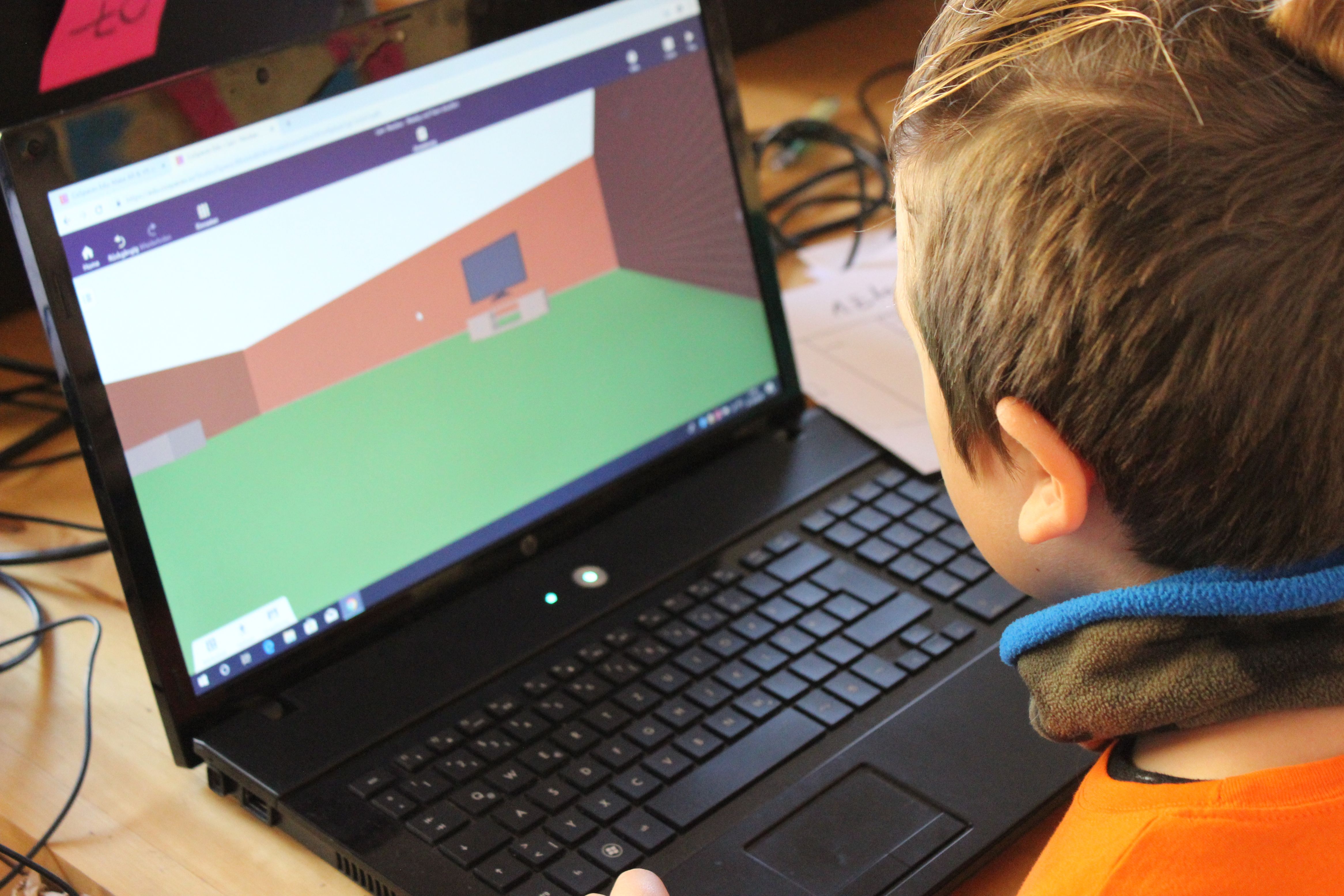 Kind mit Laptop arbeitet an der 3D-Welt