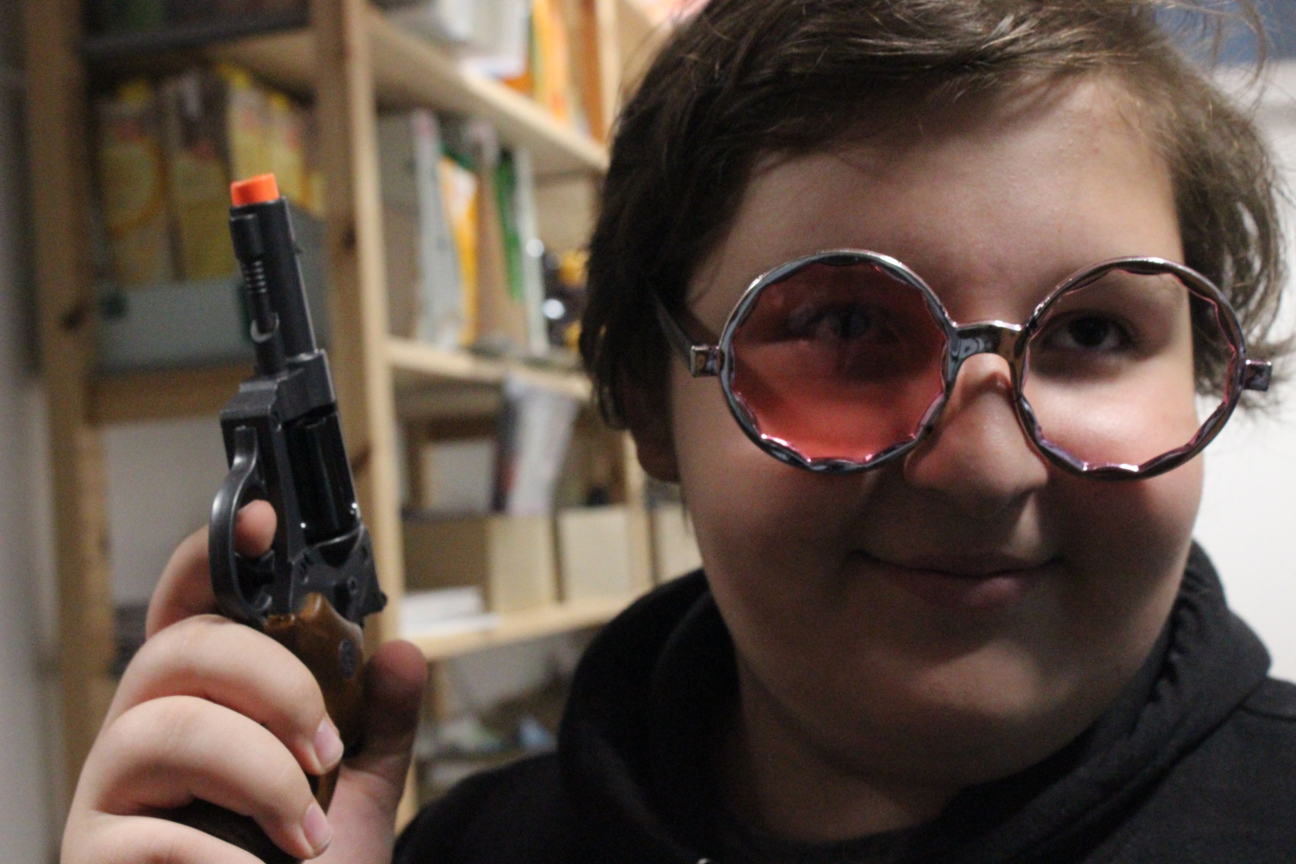 Ein Kind lächelt und hält eine Pistole in der Hand