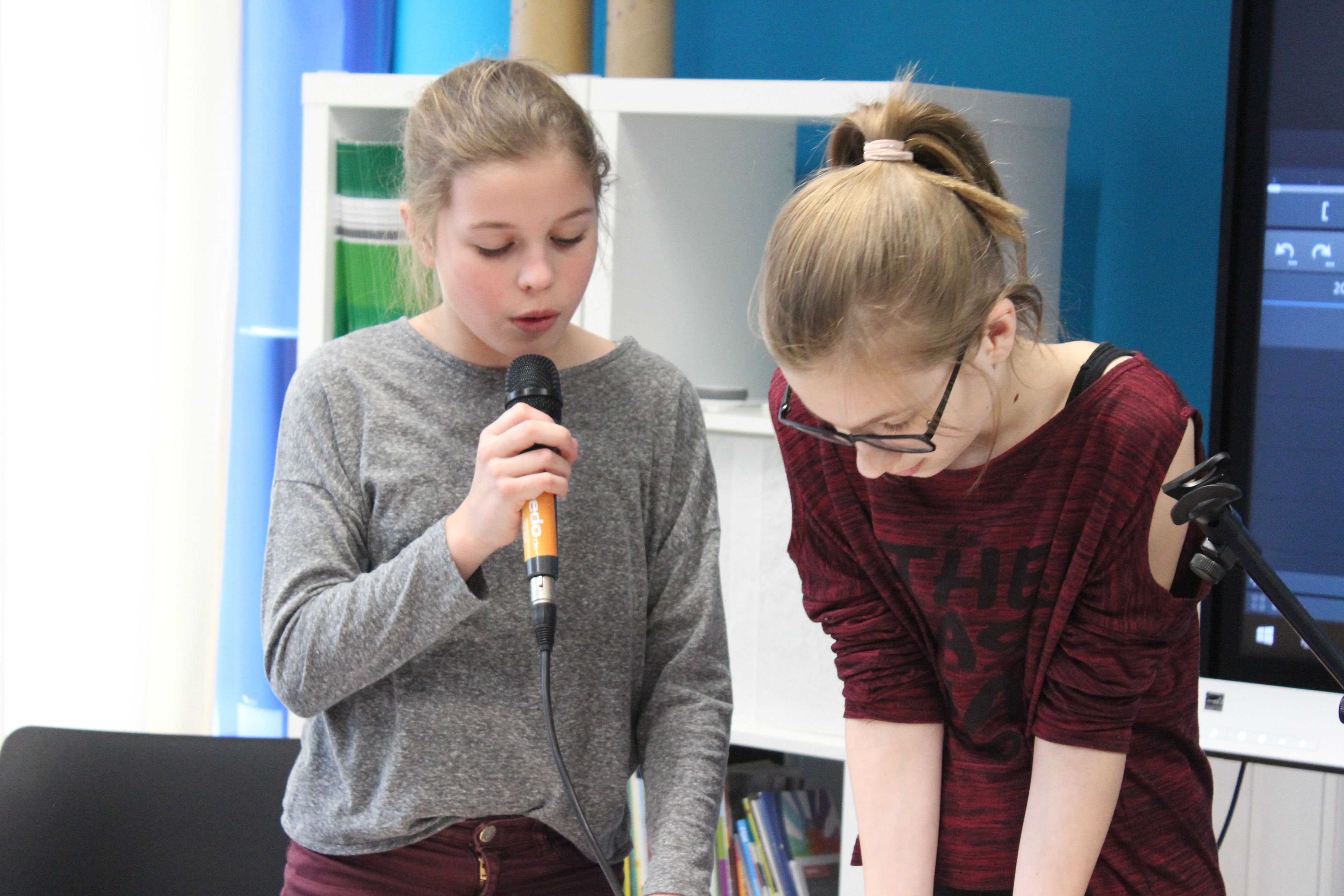 Zwei Schülerinnen machen Aufnahmen mit einem Mikrofon