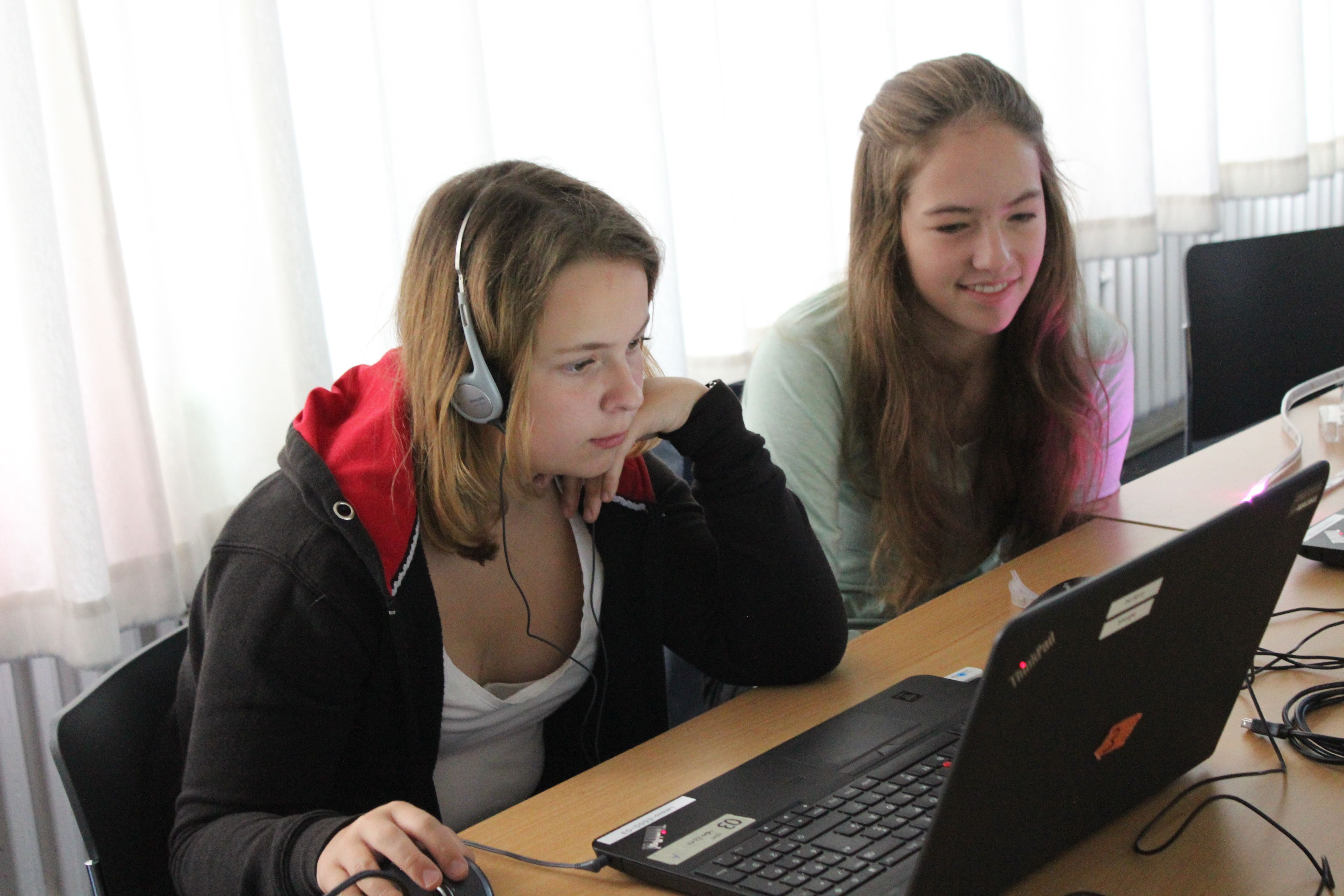 Zwei Schülerinnen sitzen vor einem Laptop
