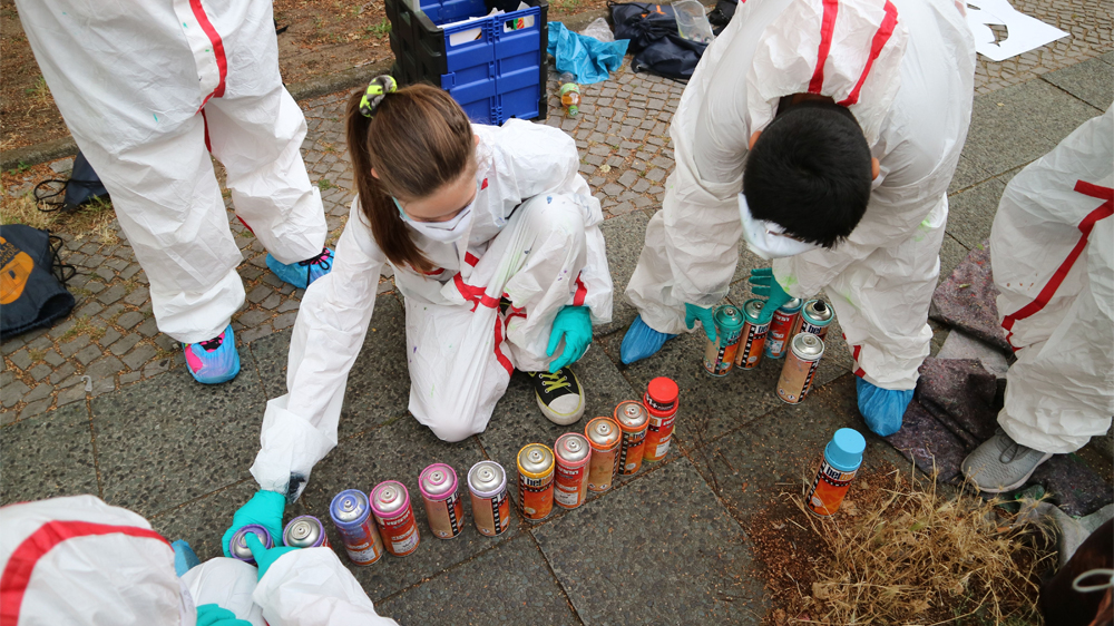 Jugendliche sortieren Farbsprühdosen